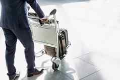 成熟的商人推行李车检查机场