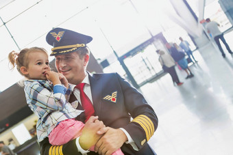肖像成熟的飞行员携带可爱的孩子机场