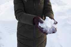 年轻的女人持有雪手连指手套冬天有趣的