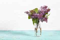 花束淡紫色花朵玻璃瓶光背景花春天纹理