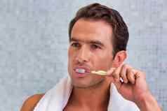年轻的有吸引力的男人。刷牙牙齿浴室