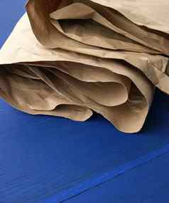折叠棕色（的）皱巴巴的卡夫纸表蓝色的木使用