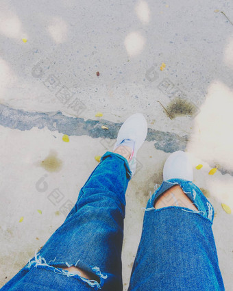 女人的腿蓝色的时尚牛仔裤白色运动鞋街
