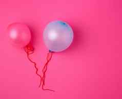 膨胀的蓝色的粉红色的橡胶气球粉红色的背景