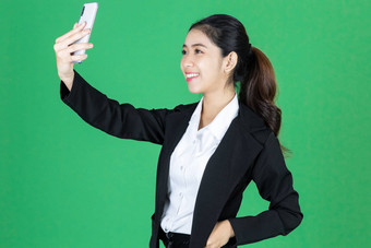 有吸引力的年轻的亚洲业务女人采取图片自拍移动聪明的电话绿色孤立的背景