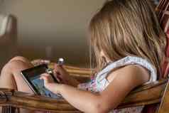 年轻的学龄前儿童玩现代电子平板电脑