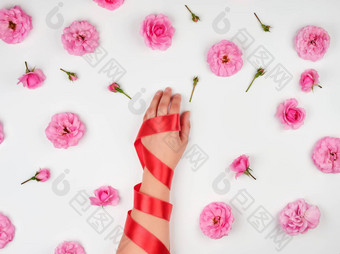 女手光滑的皮肤包装红色的丝绸丝带