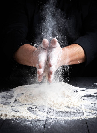 男人的手飞溅白色小麦面粉