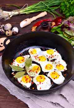 黑色的铸铁煎锅炸鹌鹑鸡蛋