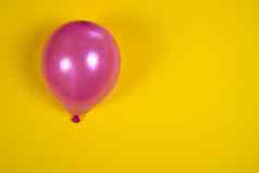 膨胀的粉红色的空气气球黄色的表面