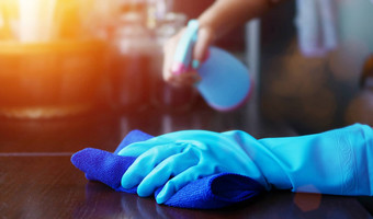 手蓝色的橡胶手套持有蓝色的超细纤维清洁布