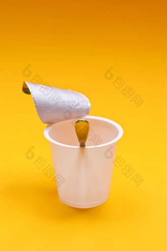 空清洁酸奶杯勺子橙色背景