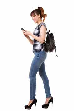 一边肖像年轻的女人走移动电话袋白色背景