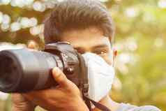 年轻的摄影师污染面具概念新闻摄影风险