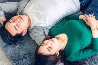 年轻的夫妇放松说谎地毯首页有吸引力的亚洲夫妇爱放松生活房间地板快乐时刻生活方式概念图片