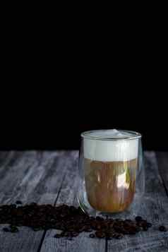 咖啡时间点心概念透明的玻璃咖啡牛奶泡沫烤咖啡豆木背景