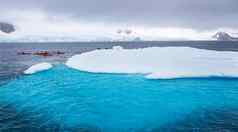 巨大的冰山蓝色的水下部分小游客皮艇