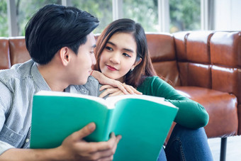 肖像年轻的夫妇爱浪漫的情绪阅读书夫妇年轻的人风扇放松生活房间快乐情感放松生活方式概念