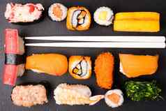 前视图寿司集筷子黑色的背景日本食物