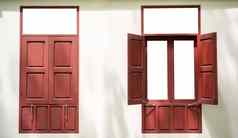 红色的木双胞胎窗户开放关闭白色墙引入