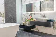 现代浴室角落里白色瓷砖墙大理石地板上白色浴缸水槽