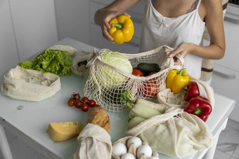 女人手持有可重用的生态纺织杂货店袋蔬菜需要红色的黄色的胡椒浪费塑料免费的概念女孩持有网棉花购物者蔬菜