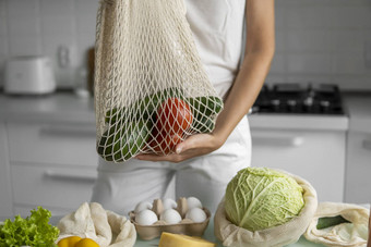 女人手持有可重用的生态纺织杂货店袋蔬菜水果浪费塑料免费的概念女孩持有网棉花购物者蔬菜