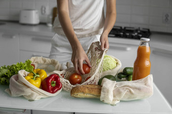 女人的手持有可重用的杂货店袋蔬菜厨房首页需要番茄浪费塑料免费的概念网棉花购物者蔬菜生态