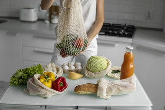 女人手持有可重用的杂货店袋蔬菜水果浪费塑料免费的概念女孩持有网棉花购物者蔬菜生态
