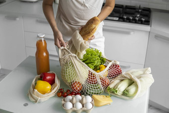 女人回来市场解包可重用的杂货店袋完整的蔬菜厨房首页浪费塑料免费的概念女孩持有网棉花购物者蔬菜