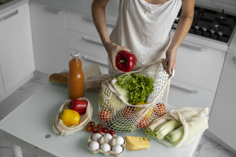 女人的手持有可重用的杂货店袋蔬菜厨房首页需要胡椒浪费塑料免费的概念网棉花购物者蔬菜生态