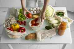 女人的手持有可重用的杂货店袋蔬菜厨房首页需要番茄浪费塑料免费的概念网棉花购物者蔬菜生态