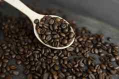 新鲜的烤Arabica咖啡豆子木勺子分散咖啡豆子木表格