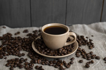 咖啡杯烤咖啡豆子亚麻背景杯子黑色的咖啡分散咖啡豆子新鲜的咖啡豆子
