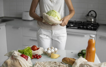 女人的手持有可重用的杂货店袋蔬菜厨房首页需要卷心菜浪费塑料免费的概念网棉花购物者蔬菜生态