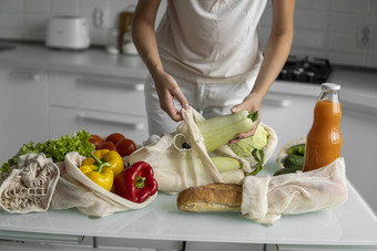 女人的手持有可重用的杂货店袋蔬菜厨房首页需要西葫芦浪费塑料免费的概念网棉花购物者蔬菜生态