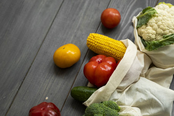 浪费概念胡椒番茄玉米黄瓜西兰花菜花可重用的购物生态友好的棉花织物袋蔬菜生态袋木表格塑料免费的概念