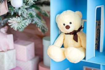 可爱的泰迪熊坐着玩偶之家圣诞节树