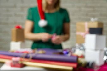 散焦背景礼物包装圣诞节一年手工制作的女孩的手礼物丝带线磁带现在包装