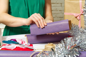 女人包装圣诞节<strong>礼物</strong>紫罗兰色的包装纸女人手包装圣诞节<strong>礼物</strong>Diy<strong>礼物</strong>包装概念