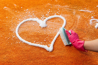 女人手清洁染色地毯硬刷橙色地毯清洁地毯清洁服务概念