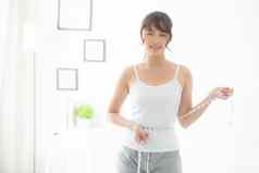 美丽的年轻的亚洲女人身体饮食苗条的测量腰重量卧室女孩脂肪团卡路里损失磁带测量健康健康概念