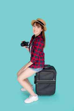 美丽的肖像年轻的亚洲女人坐着行李微笑旅行夏天旅行在国外假期快乐亚洲女孩持有相机坐着手提箱旅程快乐的假期
