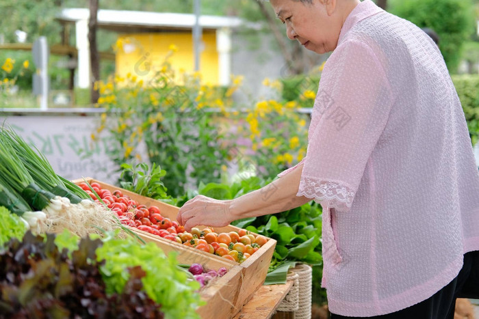 亚洲上了年纪的老女人购买蔬菜市场高级生活方式