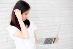 美丽的亚洲年轻的女人赶时髦的人工作移动PC思考的想法水泥混凝土背景女孩怀疑问题电脑互联网在线自由业务概念