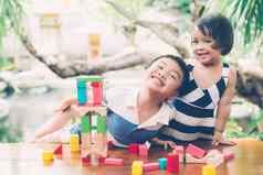 亚洲男孩格里尔玩木块玩具表格有创意的发展享受快乐孩子学习技能活动谜题创造力游戏桌子上首页教育概念