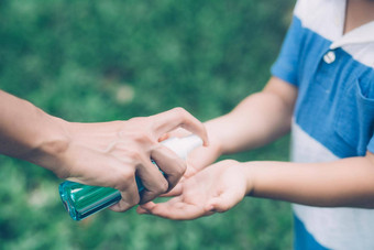 妈妈。护理儿子洗手液保护疾病流感科维德清洁手在户外孩子洗手安全爆发流感大流行公共卫生生活方式概念