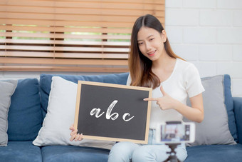 年轻的亚洲女人老师<strong>教学</strong>语言英语学生电子学习在线首页女孩工作会说话的教训类智能手机保持首页正常的教育概念