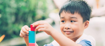 亚洲年轻的男孩玩木块玩具表格有<strong>创意</strong>的发展快乐孩子学习技能活动谜题创造力游戏桌子上首页<strong>教育</strong>概念横幅网站