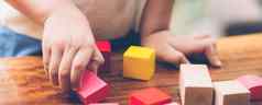 特写镜头手男孩玩木块玩具表格有创意的享受快乐孩子学习技能活动谜题创造力游戏桌子上首页教育概念横幅网站